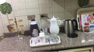 eine Arbeitsplatte mit einem Tablett mit Geschirr und einem Mixer in der Unterkunft Al Marwa Apartment in Dokki - Families Only in Kairo