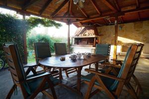 a wooden table and chairs on a patio with a fireplace at Edem Seaside Villa in Paralía Avdhíron
