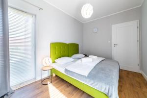 a bedroom with a large bed with a green headboard at Komfortowy Apartament w Karpaczu do 5 os. in Karpacz