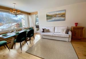 sala de estar con sofá y mesa con sillas en Bilocale nuovo St. Moritz Chesa Arlas, en St. Moritz