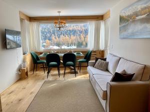a living room with a couch and a table with chairs at Bilocale nuovo St. Moritz Chesa Arlas in St. Moritz
