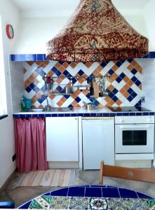 L'Antico Frantoio في رابالو: مطبخ مع مغسلة وموقد فرن علوي