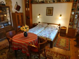 Un dormitorio con una cama y una mesa con flores. en Bike Stop Duna en Dunaszentmiklós