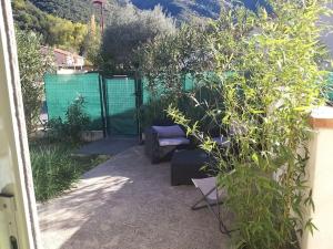 einen Garten mit einer Bank, Pflanzen und einem Zaun in der Unterkunft Rez de jardin cosy avec terrasse fleurie in Arles-sur-Tech