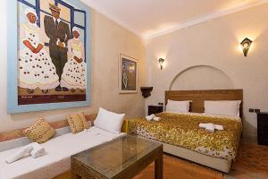 een slaapkamer met een bed, een tafel en een bank bij Riad Wardate Rita in Marrakesh