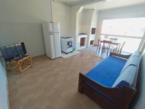 a bedroom with a bed and a kitchen with a refrigerator at Pousada Colibris in Pinhal