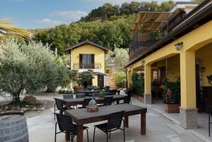 a patio with tables and chairs and a building at La Dolce Vallata in Montefiore dellʼAso