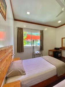 a bedroom with a large bed and a window at Pelican Beach Maafushi in Maafushi