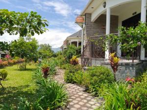 a garden in front of a house with plants at Home Bliss Hotel- Fort portal Uganda in Fort Portal