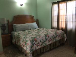 
a bed in a room with a wooden floor at Antigua Seaview in Saint Johnʼs
