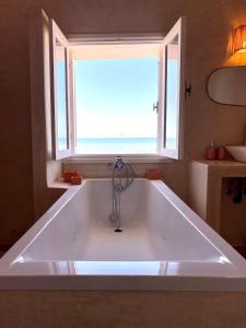 baño con bañera grande y ventana en Hostel La Smala, en Essaouira