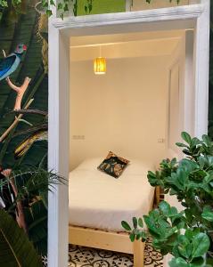Cama pequeña en habitación con plantas en Hostel La Smala en Esauira