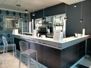 un bar in un ristorante con due sedie di Hotel Parisi a Nichelino