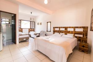 ein Schlafzimmer mit 2 Betten und ein Badezimmer in der Unterkunft HOTELARE Pousada Bóra Morá in Ubatuba