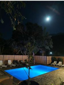 - une piscine bleue la nuit avec une lune dans l'établissement Ruta Elqui, à Pisco Elqui