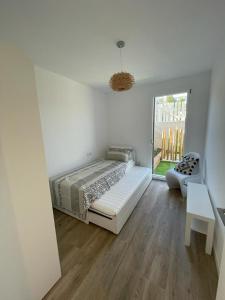 a white bedroom with a bed and a window at L'ARMONIA entre la Farella i Cau del LLOP in Llança +24 photos