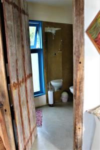 an open door to a bathroom with a toilet and a sink at CantaGalo Ilhabela - Onde o Galo Canta de tão linda a vista in Ilhabela +12 photos