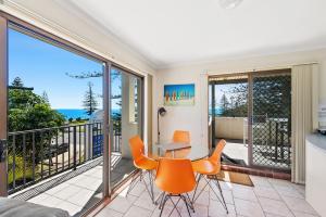 a living room filled with furniture and a window at Beach House Holiday Apartments in Port Macquarie