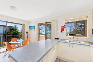 a kitchen with a sink and a counter top at Beach House Holiday Apartments in Port Macquarie