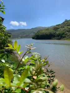uma vista para um rio com montanhas ao fundo em Recanto Nativos em Garopaba