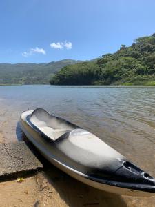 um barco sentado na margem de um rio em Recanto Nativos em Garopaba