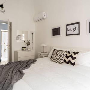 a white bedroom with a large white bed with aigil pillow at FLAT 07 - New Opening in Rome
