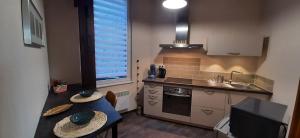 eine kleine Küche mit einem Tisch und einem Waschbecken in der Unterkunft Le Rohan in Colmar