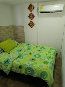 a bedroom with a green comforter on a bed at Villa mar in Puerto Colombia