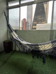 uma rede de descanso num quarto com uma grande janela em Apartamento Alameda Santos - By Capsula Hotel em São Paulo