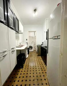 uma cozinha com electrodomésticos brancos e um piso xadrez em Apartamento Alameda Santos - By Capsula Hotel em São Paulo