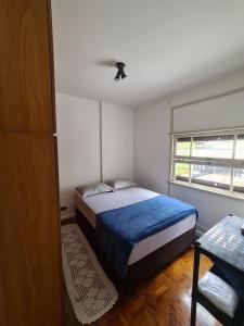 um pequeno quarto com uma cama e uma janela em Apartamento Alameda Santos - By Capsula Hotel em São Paulo