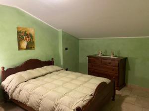 a bedroom with a bed and a dresser and a painting at L'Albicocco in Dolceacqua