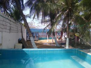 a swimming pool with palm trees in the background at Villa mar in Puerto Colombia
