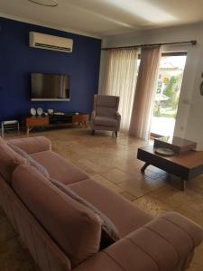 ein Wohnzimmer mit einem Sofa und einem TV in der Unterkunft Villa Bade in Dalyan