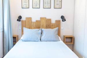 a bed with a wooden headboard and two pillows at Envalira Vacances - Dolsa in Pas de la Casa