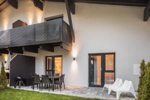 Falcon Suites Kaprun - Summercard included في كابرون: منزل مع فناء مع طاولة وكراسي