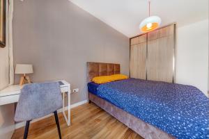 um quarto com uma cama, uma secretária e uma cadeira em Consulate em Podgorica
