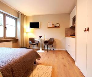 a bedroom with a bed and a table and chairs at Apartmenthaus Schön in Bad Neustadt an der Saale