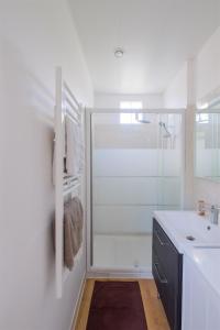 ein weißes Bad mit einer Dusche und einem Waschbecken in der Unterkunft Les Suites d'Aliénor-Suite Acanthe in Pessac