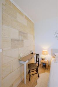 Zimmer mit einem Schreibtisch und einem Stuhl neben einer Wand in der Unterkunft Les Suites d'Aliénor-Suite Acanthe in Pessac