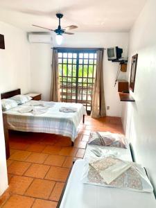 a room with two beds and a television and atained at Pousada Do Farol in Capão da Canoa +38 photos