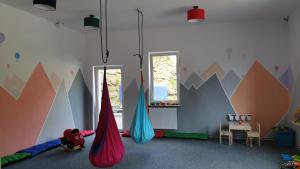 a room with two hammocks in a room with mountains on the wall at Morze Gór in Duszniki Zdrój