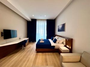 a bedroom with a bed and a desk and a television at Condo Studio Plaza in Budva