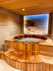 Habitación con bañera de madera grande y TV grande. en Chalet Pleine Vue & Spa, en Chamonix-Mont-Blanc