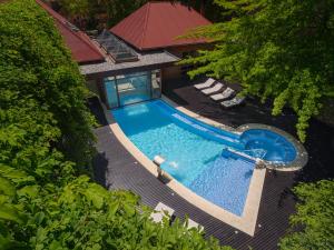 uma vista sobre uma piscina com 2 espreguiçadeiras em Amonite Apart & Spa em San Martín de los Andes