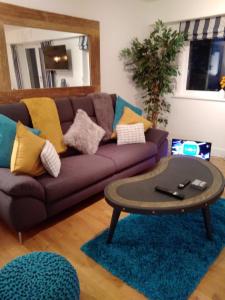 uma sala de estar com um sofá roxo e uma mesa de centro em Fistral beach apartment em Newquay