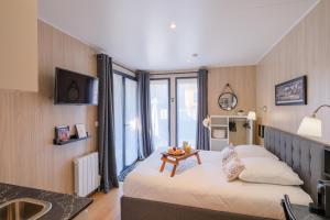 ein Hotelzimmer mit einem Bett und einem Tisch in der Unterkunft Les Suites d'Aliénor-Suite Mimosa in Pessac