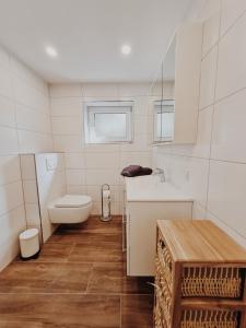 uma casa de banho branca com um WC e um lavatório em Ferienwohnung am Waldrand em Kalletal