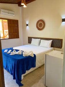 a bedroom with a bed with two towels on it at Hotel e Pousada Tetiaroa in Barra Grande