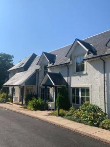 a row of houses with roofs on a street at Ryder Cup Lodge Duchally - Free access to Leisure Club Swimming Pool Hot Tub Steam Room and Gym - Starlink Satellite Internet - Sky Glass Now DOG FRIENDLY for 2024 in Auchterarder